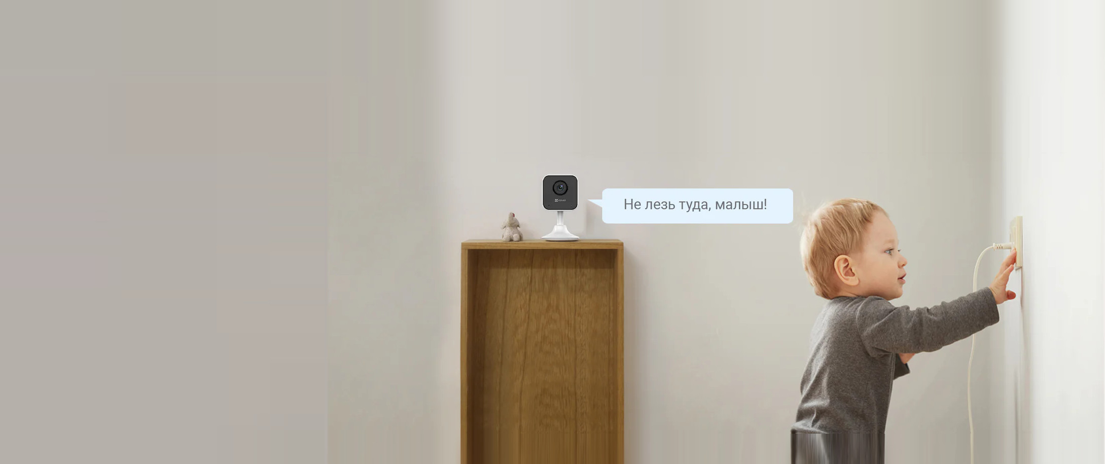 Домашняя камера EZVIZ H1C на комоде смотрит за ребёнком у розетки
